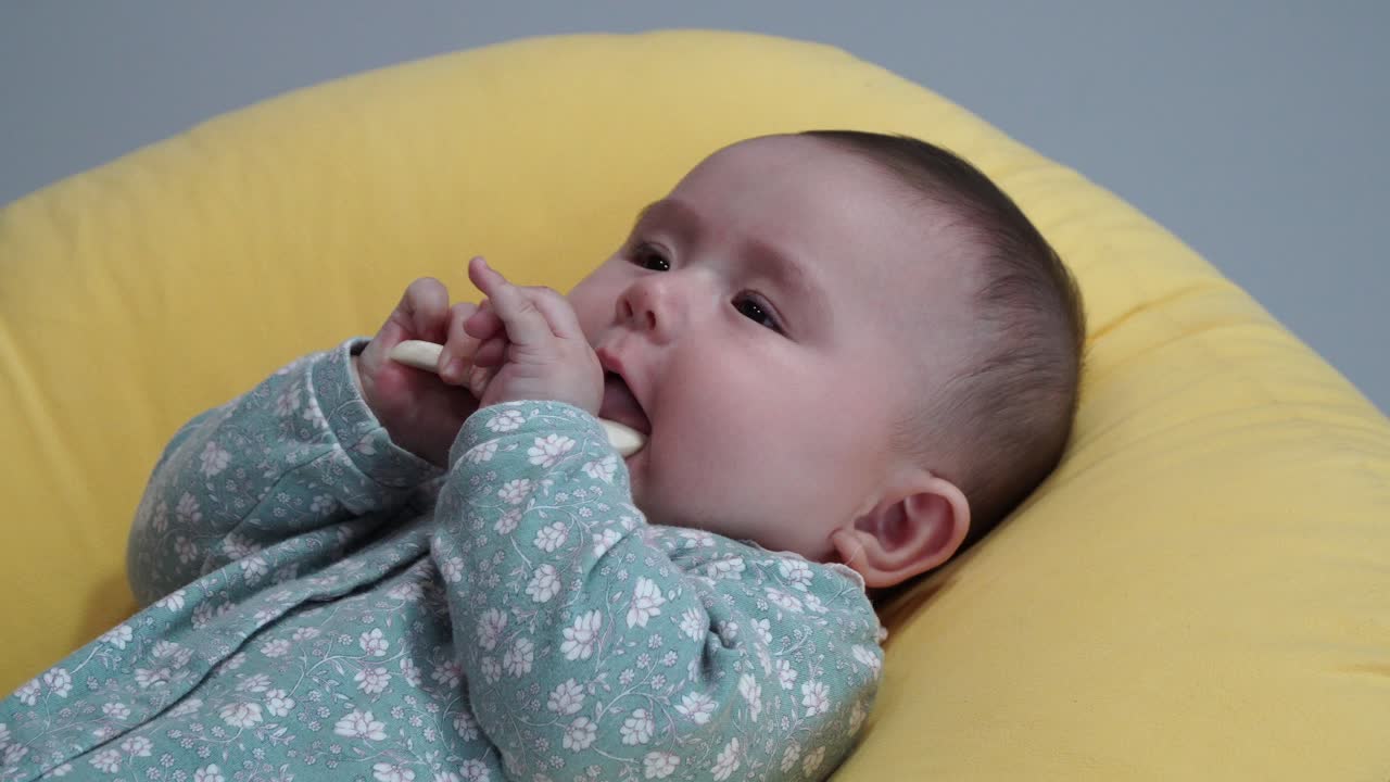 그녀의 뒤에 누워있는 동안 빵을 먹는 사랑스러운 귀여운 신생아