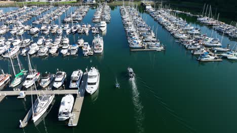 Luftaufnahme-Eines-Bootes,-Das-In-Den-Sicheren-Hafen-Einfährt,-Während-Ein-Kleineres-Schlauchboot-Zu-Einem-Abenteuertag-Aufbricht