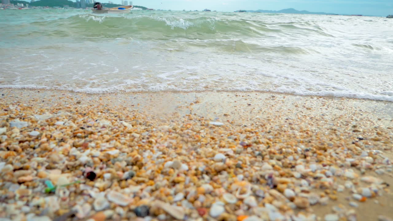 해가 지는 동안 열대 지방의  ⁇  모래 해변의 해안에 도달하는 파도와 함께 아름다운 해변