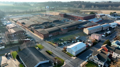 rising aerial pullback reveals small town with manufacturing plant