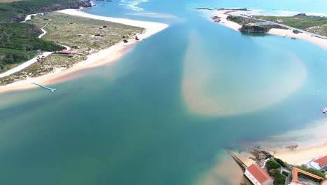 aerial view over small coastal town, blue ocean, red roofs, 4k