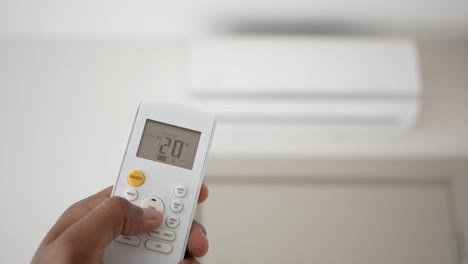 person adjusting air conditioner settings