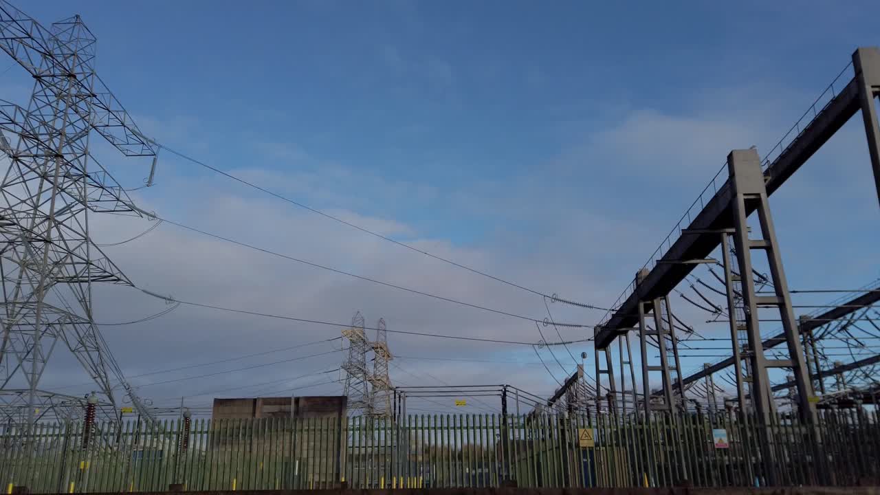 Tracking shot of mains electric grid pylon supply in England UK