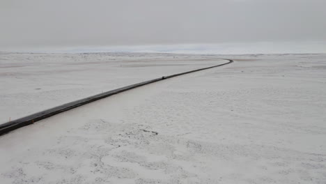 aerial: side follow of one car driving on snowy road