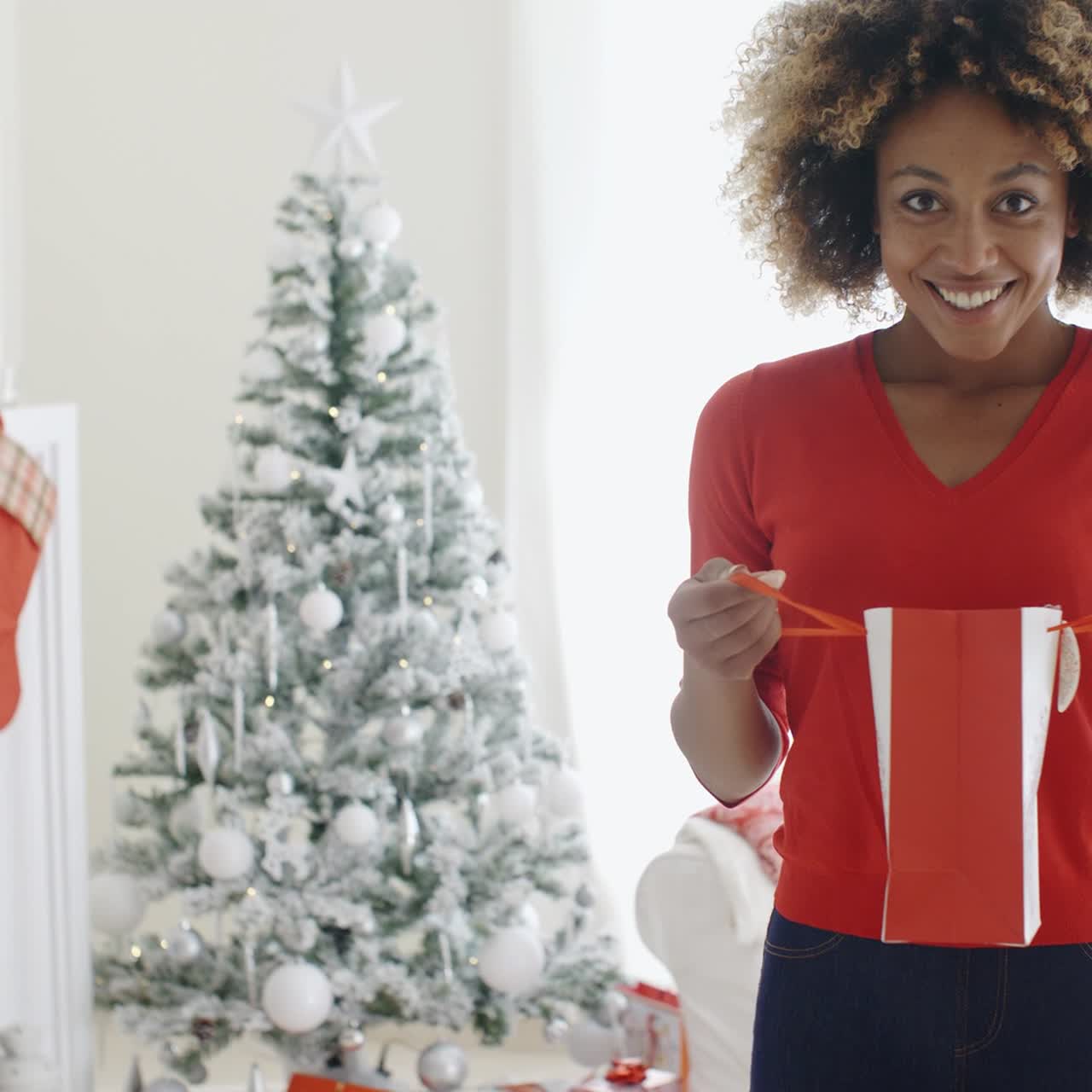 mujer joven feliz abriendo regalos de navidad