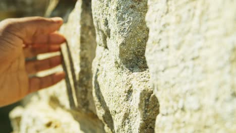 4K-footage-of-black-male-hand-stroking-an-old-brick-wall,-within-the-ruins-of-St-Peter's-Church