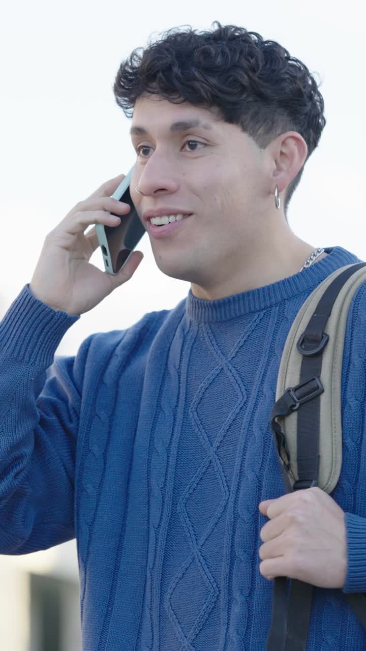 Young student talking on phone while walking. Vertical