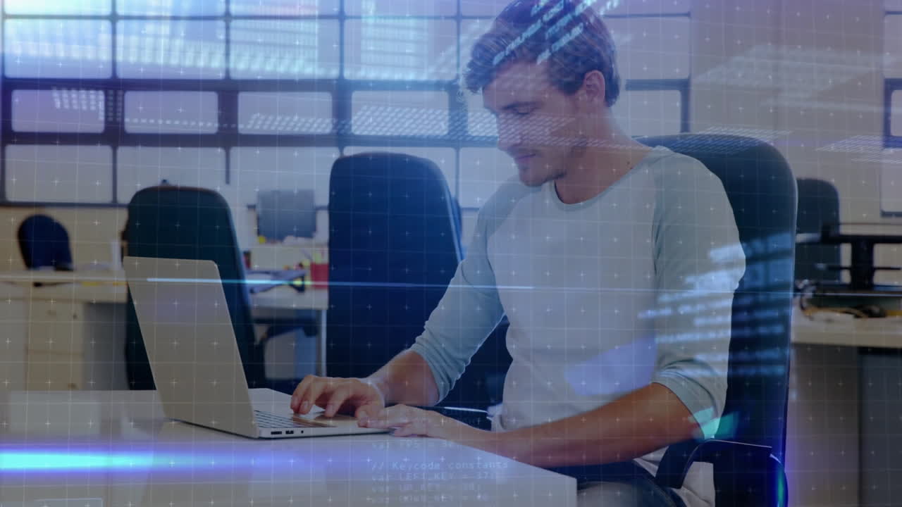 Man typing on laptop in modern tech office, showcasing digital grid and blue light flares