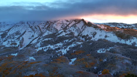 primera luz kebler paso crested butte gunnison colorado estaciones accidente aéreo drone temprano en el otoño árbol de aspera rojo amarillo bosque naranja invierno primera nieve frío amanecer nubes cimas rocosas de las montañas izquierda movimiento