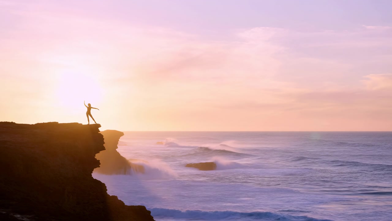 Solitary silhouette stands on rugged cliff edge with arms extended in calm balance facing glowing ocean horizon, pastel sunrise sky, soft clouds, dramatic spray, and peaceful coastal view