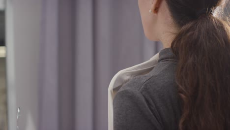 Close-Up-Of-Woman-At-Home-Choosing-Business-Suit-For-Job-Interview-Reflected-In-Mirror