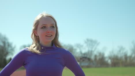 Teen-girl-on-the-track-checks-the-time-on-her-watch-after-a-run-as-she-walks-camera-precedes-in-slow-motion