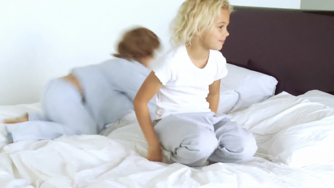 침대에서 놀고 있는 두 아이