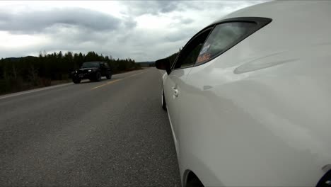 side view of a white car parked on the side of the road