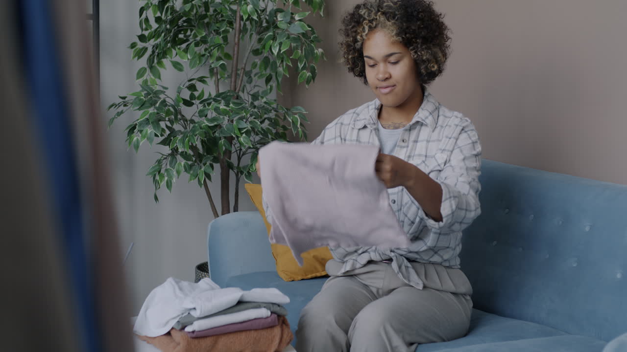 Woman Folding Laundry on a Couch