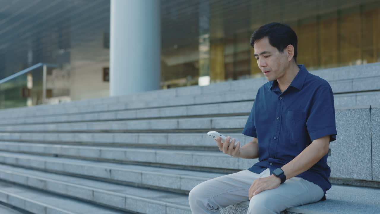 밖에서 스마트폰을 사용하는 남자