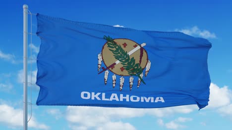 la bandera de oklahoma en un asta de bandera ondeando en el viento, fondo de cielo azul. 4k