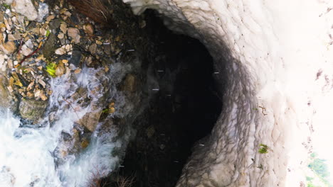 el vuelo del dron sale del túnel debajo del cañón provo cubierto de avalanchas durante el deshielo