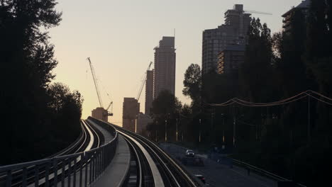 the beautiful, captivating sunrise view of vancouver city travelling from the famous millennium line - medium shot