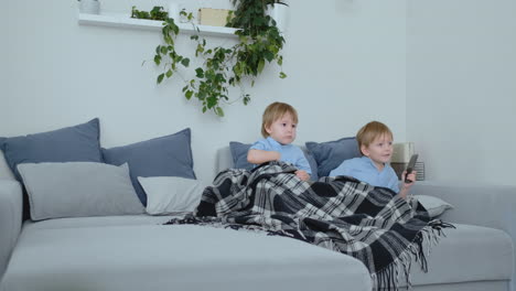 two children watch an exciting tv show on tv. two brothers are watching tv