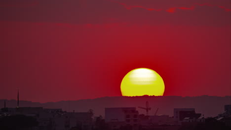 Telephoto-view-of-the-sun-setting-over-Rabat,-Malta---time-lapse-of-a-fiery-sky