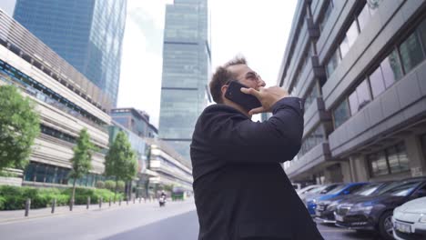 Bearded-Man-Walking-Along-The-City-Street-And-Talk-By-Phone