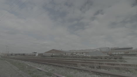 timelapse de una estación de tren desierta en bélgica con nubes en movimiento creando sombras en el registro de tierra