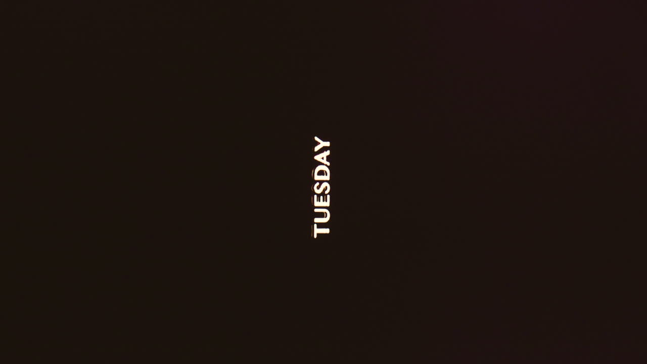 Tuesday word on vertical dark background with analog broken VHS stylized effect