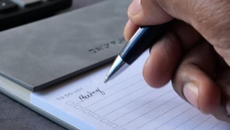 person writing a to-do list for a meeting