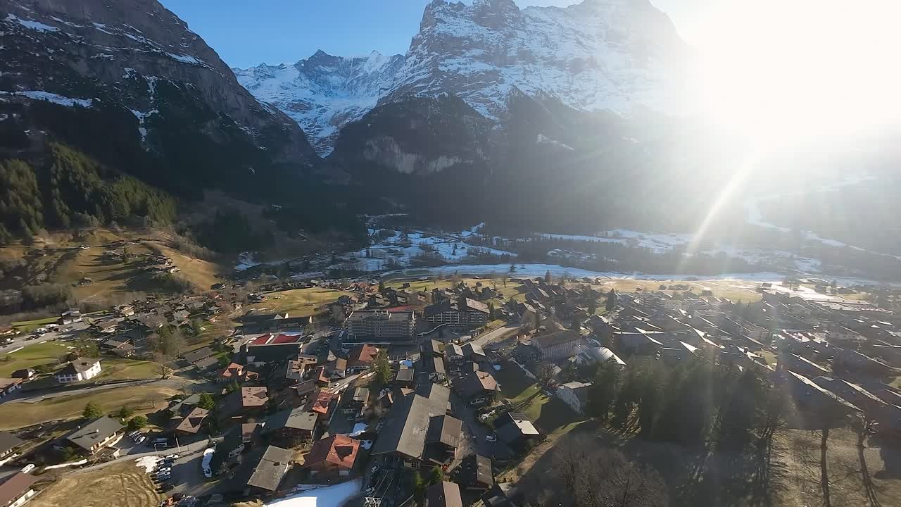el pueblo de grindelwald con la brillante luz del sol brillando a través del paso de la montaña