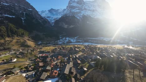 village of grindelwald with bright sunlight shining through mountain pass