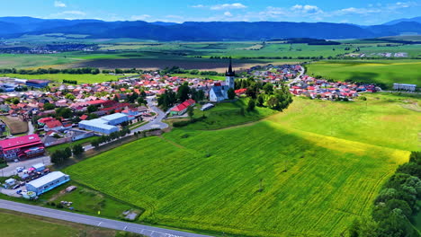 rural village with fields view. a picturesque aerial view showcases a small village surrounded by green fields and mountains on a clear day