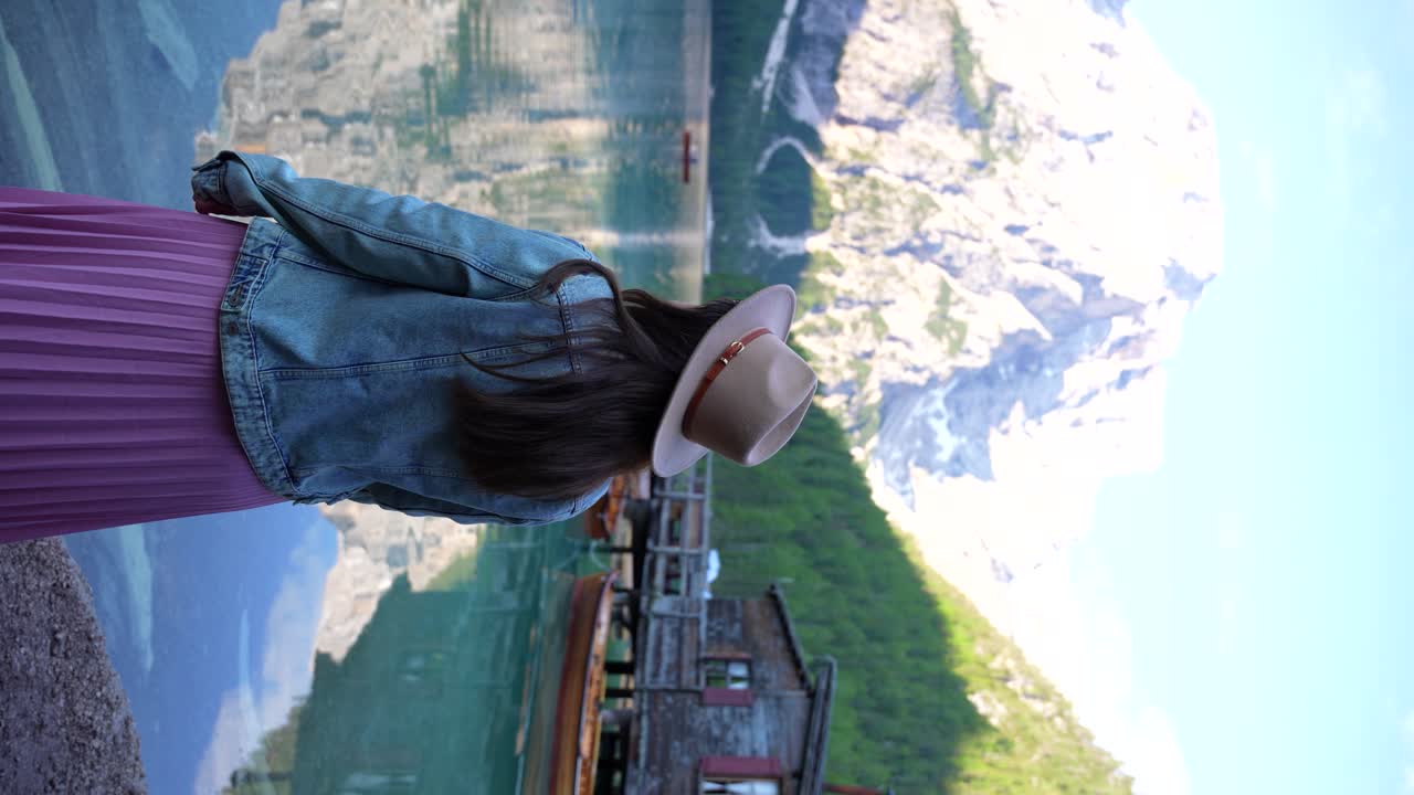 mujer disfrutando de la vista panorámica del lago di braies en las dolomitas, italia