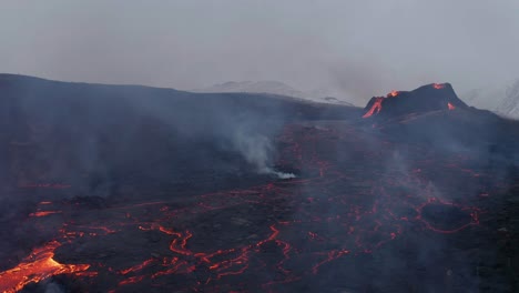 lava humeante del volcán en explosión de la montaña fagradalsfjall durante la nevada en la península de reykjanes, en el sur de islandia