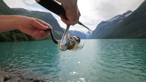 Woman-fishing-on-Fishing-rod-spinning-in-Norway.