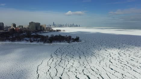 Cloud-shadows-moving-over-ice-at-the-Promontory-Point,-sunny,-winter-day-in-Chicago,-USA---Aerial-view