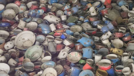 a pile of colorful enamel dishes taken from auschwitz prisoners
