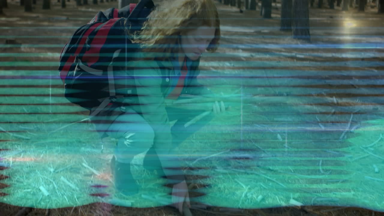 woman hiker crouching in pine forest, health app displaying glitch scan-line animated overlays