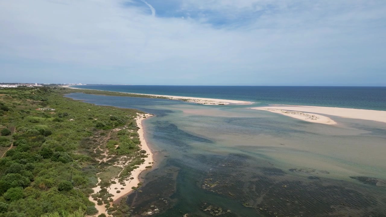Filmato aereo con drone di Cacela Velha, Portogallo: storico villaggio bianco, laguna costiera e litorale atlantico sotto una luce chiara. Ideale per progetti di viaggio e turismo.