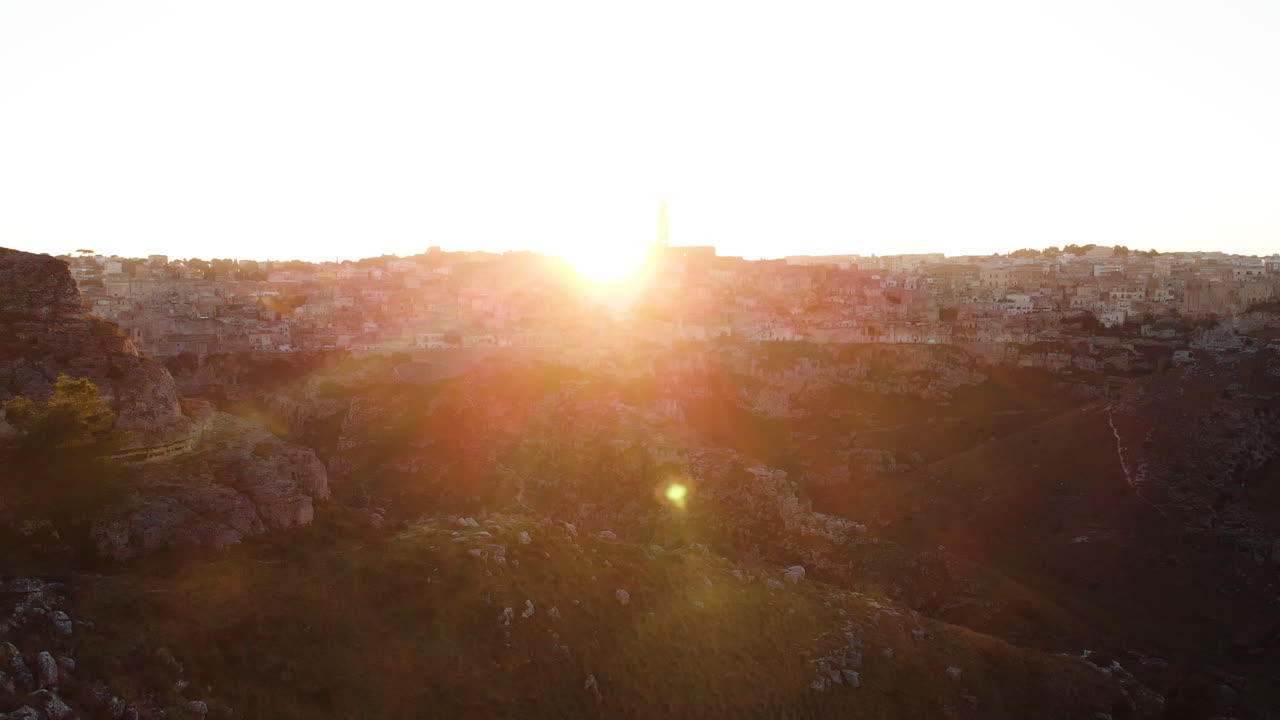 The beautiful sunset over the rocky mountains and city of Matera, Italy - aerial