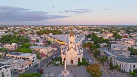 Aerial-orbii9tng-shot-of-famous-Cathedral-San-Pedro-Apostol-during-golden-sunset-in-the-evening---People-on-square-and-parking-cars-on-road