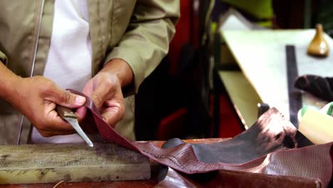 cobbler cutting a piece of leather