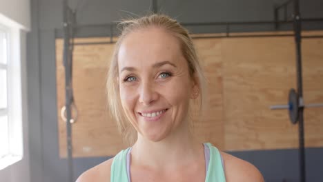 portrait of happy unaltered caucasian woman taking a break from cross training at gym, slow motion