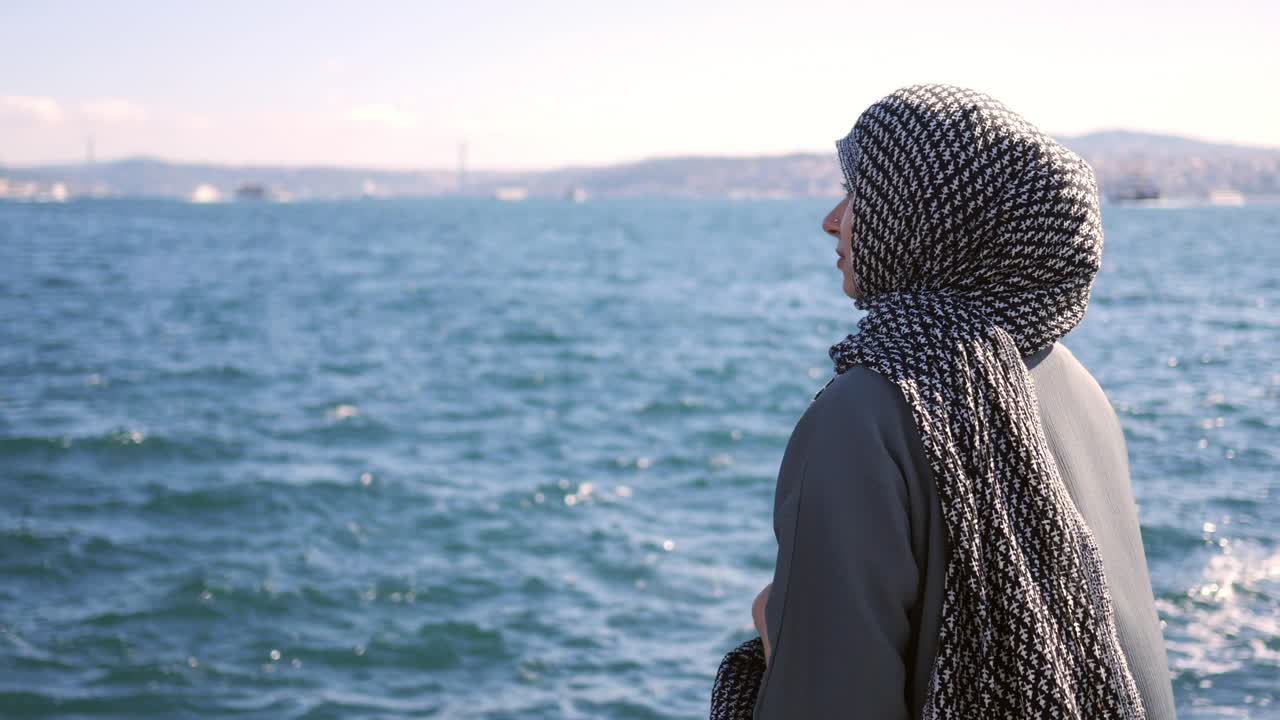 mujer en hijab junto al océano
