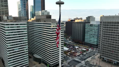 Aerial-orbit-of-American-flag-at-rest-in-USA-urban-downtown-city