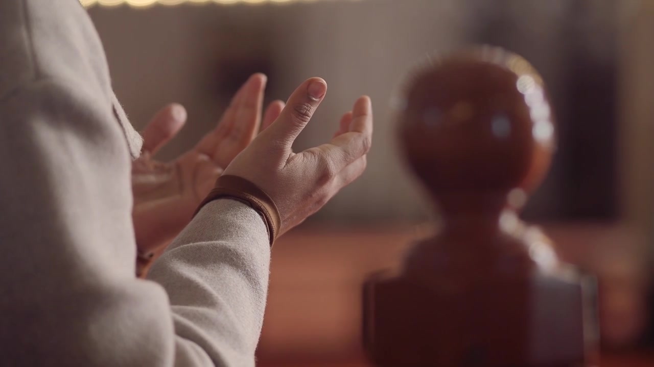 Person Praying with Hands Raised in a Place of Worship