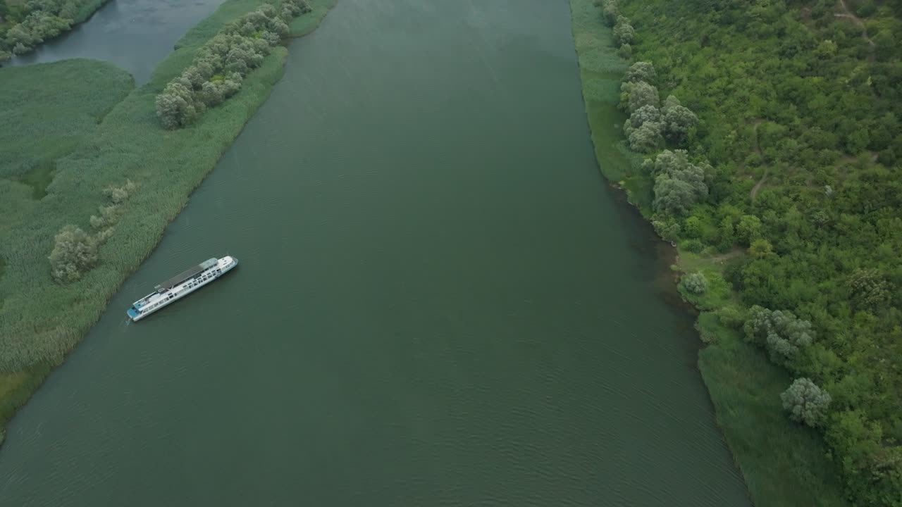 плавное вращение камеры дрона сверху вниз, наша к реке и дальше к горизонту