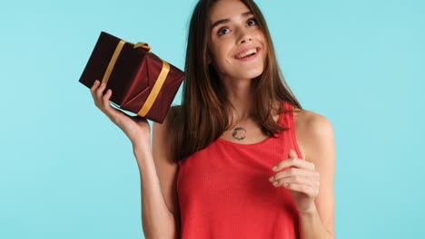 caucasian woman posing in front of camera on blue background.