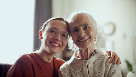 portrait of cheerful woman with elderly grandmother at home