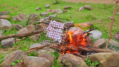 preparación de fogatas en campo verde para asar algunas brochetas de carne al aire libre